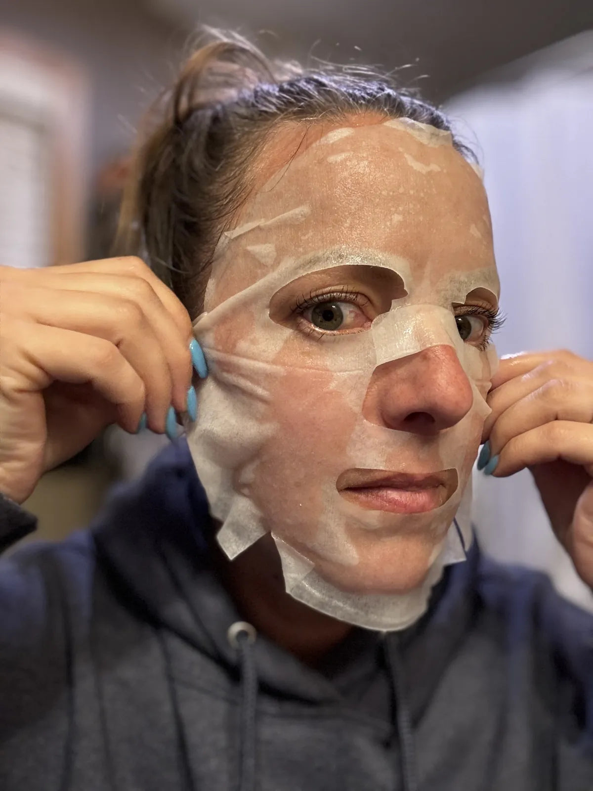 Woman showing snail mask on face